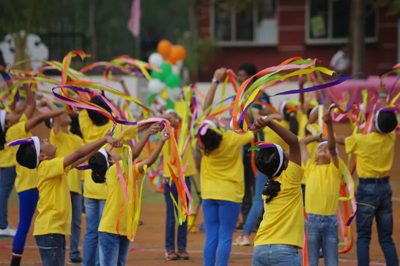 Students dancing with bright ribbons at the annual day