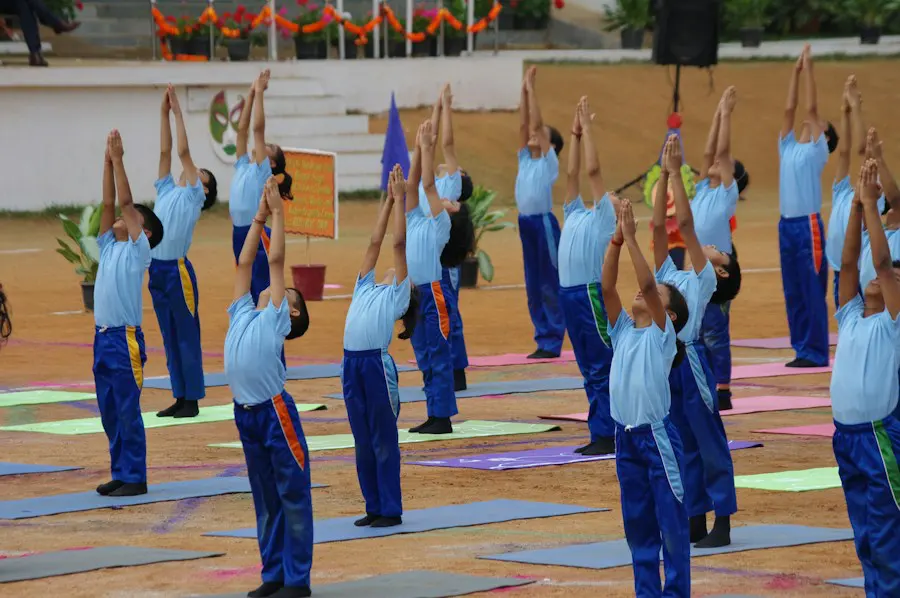 Rows of students doing yoga together on the school field
