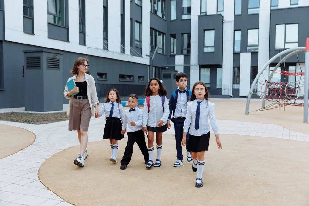 A teacher walking across the campus with a group of students
